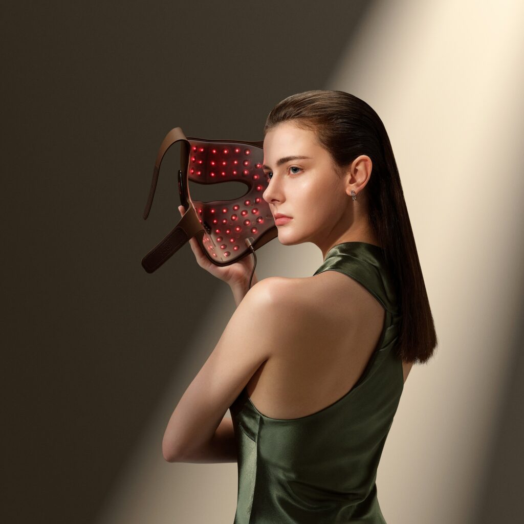 Female holding LED light therapy mask